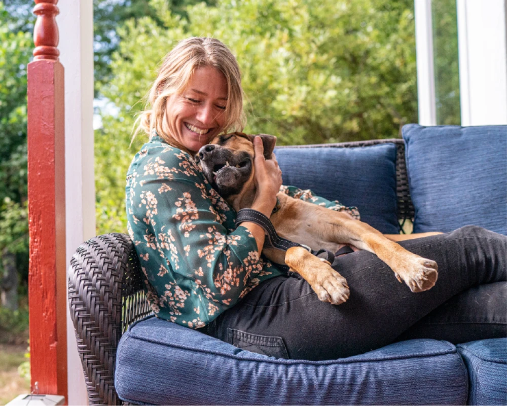 An owner hugging their dog, the kind of loving care Mary provides